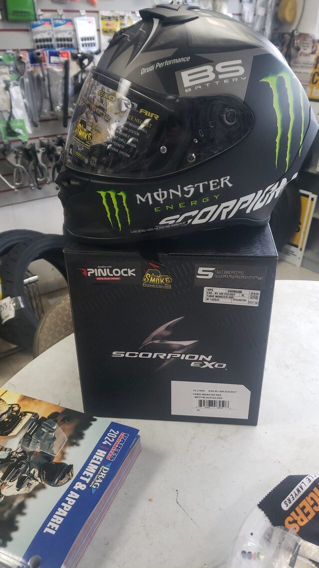 A Scorpion helmet on the parts counter in front of the accessory wall